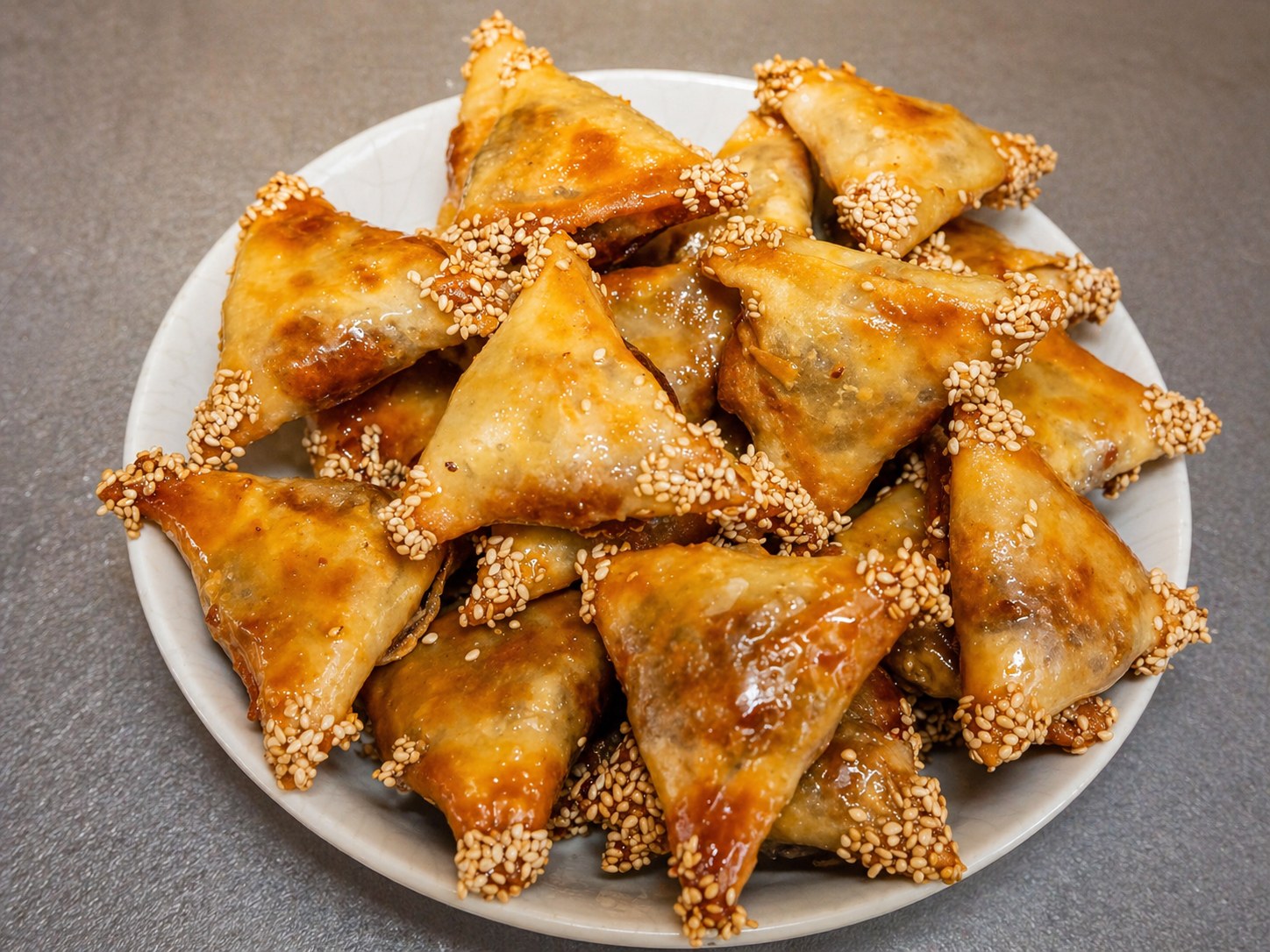 Honey-glazed briouats — sesame-coated almond pastries